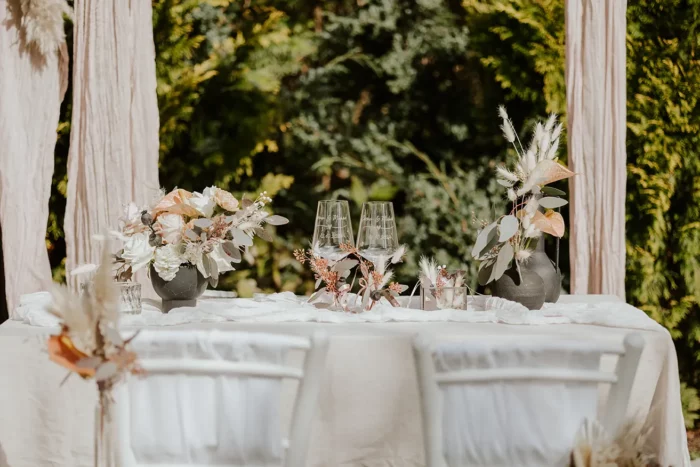Trauungstisch mit Blumen und Gläsern im Garten