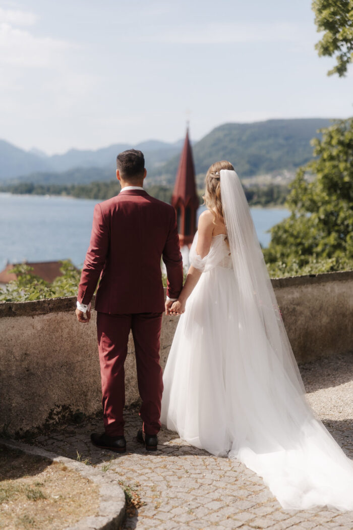 Brautpaar Isabella und Daniel Hemetsberger von hinten mit Blick auf den See