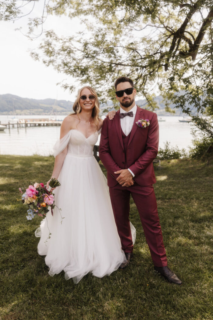 Brautpaarporträt von Isabella und Daniel Hemetsberger mit Sonnenbrillen im Grünen