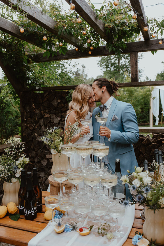 Agape mit Prosecco-Tower unter der Pergola, Dolce-Vita-Hochzeit im PreunerWirt-Garten