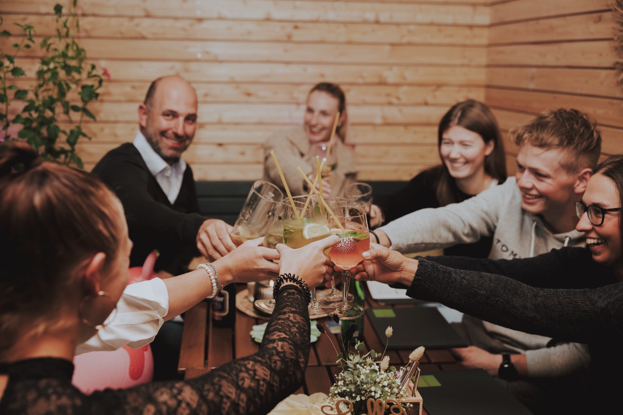 Familie und Freunde stoßen am Tisch im Restaurant PreunerWirt an