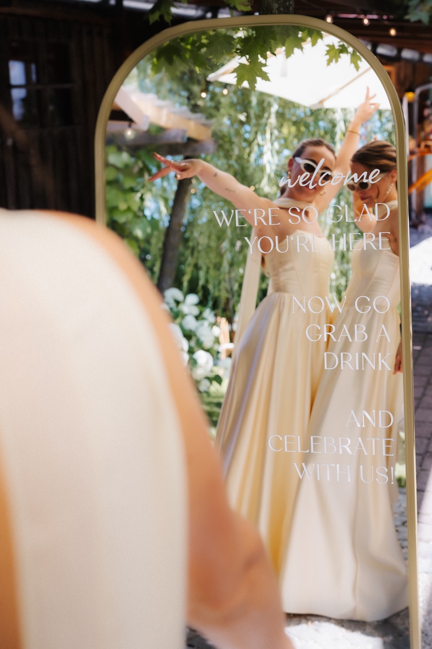 Bridesmaids im Spiegel des Willkommensschilds