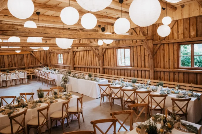 Festlich gedeckter Holzstadl mit Lampions für eine Hochzeit beim PreunerWirt